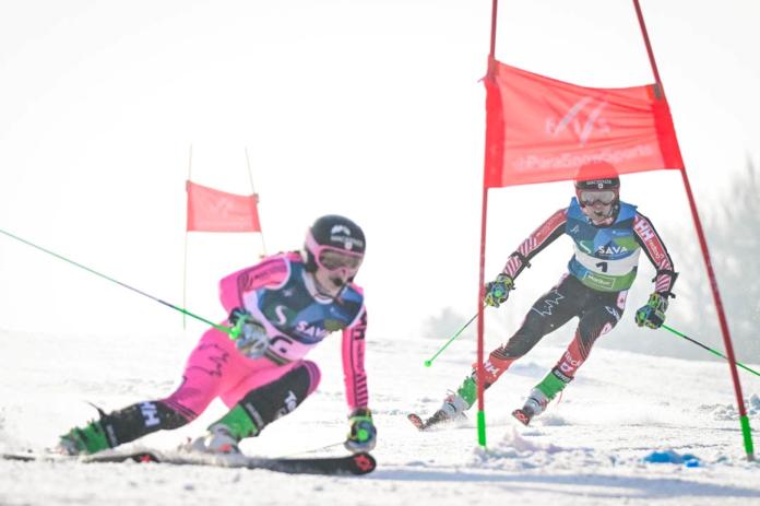 A male Para alpine skier is racing behind a female guide